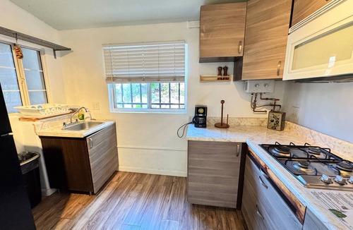 San Antonio del Mar Apartment | A bright, colorful escape just 3 blocks from the ocean in San Antonio del Mar. Sage-green walls and breezy teal curtains set a laid-back coastal mood, with a comfy queen bed, sofa bed, and full kitchen. Shared laundry available in the garage area.